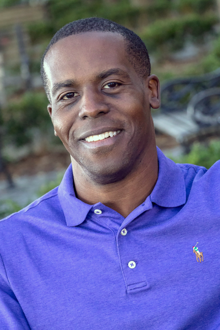 young black man smiling headshot in purple short sleeve dating profile photo